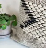 Housse de coussin marocaine faite main en blanc et noir avec détails en laine blanche