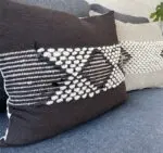 black Moroccan handmade cushion cover with white stripes and wool decorations, close