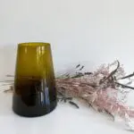 Marockansk handblåst vas i brunt med blommor bakom