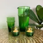 Marokkanische handgefertigte Teelichthalter aus grünem Glas mit Teelichtern neben anderem grünen Beldi-Glas