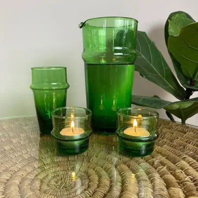 groene Marokkaanse mondgeblazen beldi kan zonder handvat naast andere groene glazen voorwerpen