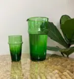 grüner marokkanischer mundgeblasener Beldi-Krug ohne Henkel neben Beldi-Glas