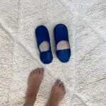 Marokkanske håndlavede slippers i blå med fodmodel ved siden af