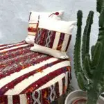 Großer handgefertigter Boho-Pouf mit marokkanischem Design und Kissen darauf