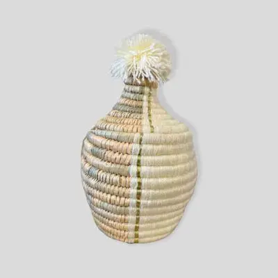 Small Moroccan handmade basket in natural rattan and white with tassel on top of the lid