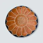 Round hand-stitched denim pouf with leather Moroccan pattern on top, from above