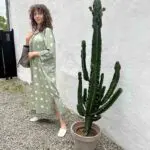 Model in Moroccan handwoven dress in light green with white dots next to cactus