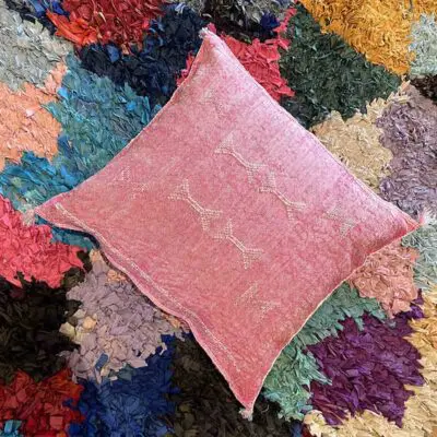 Housse de coussin marocaine en soie de cactus tissée à la main en rose sur tapis boucheroite