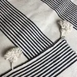 Weiße marokkanische handgewebte Tagesdecke mit schwarzen Streifen und weißen Pompons