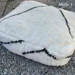 Fyrkantig marockansk handsydd golvkudde i ull med två stora svarta ränder, från sidan