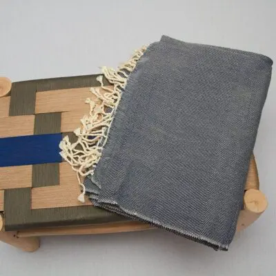Moroccan handwoven bedspread in blue, on a bench