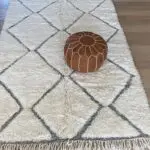 Pouf marocain marron clair sur un tapis beni ouarain blanc