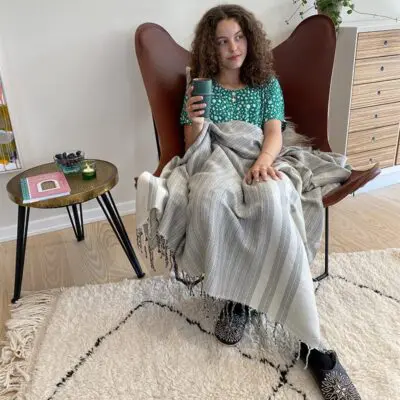 Model zittend in een stoel met je gids voor Marrakech-boek ernaast, bovenop een tafel
