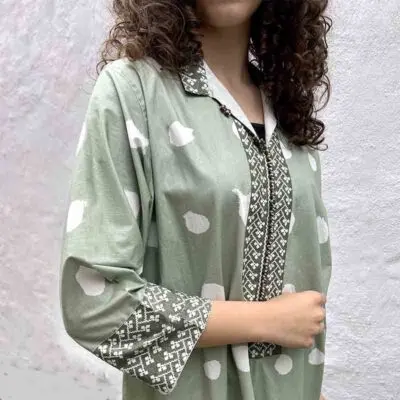 Model in Marokkaanse handgeweven jurk in lichtgroen met witte stippen, strak