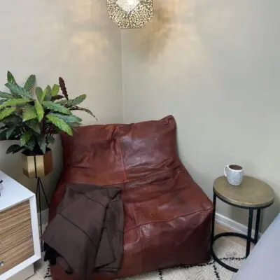 Moroccan handmade bean bag chair in cognac colored leather standing in a reading corner