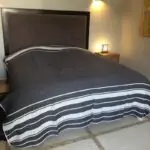 Couvre-lit marocain en herbe avec pompons blancs sur un lit