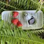 Kleine handgemaakte tajinekom met stippenpatroon, op een bord met hetzelfde stippenpatroon, en aardbeien en decoraties