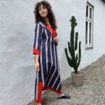 Modell i marockansk handvävd klänning i blått med röda och vita ränder