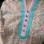 Model in Moroccan handwoven tunic with multicolored floral pattern, tight