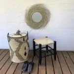 Moroccan handmade stool in black, next to black basket and black slippers