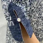 Modell in handgewebtem marokkanischem Jeanskleid mit Blattmuster, eng an den Armen anliegend