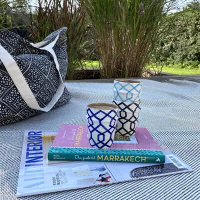 Jouw gids voor Marrakech-boek met een keramische mok erop, bovenop een vloerkleed