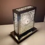 Handmade square table lamp with Moroccan pattern, lit in the dark, from the side