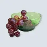 Large handmade green beldi glass bowl with grapes in it