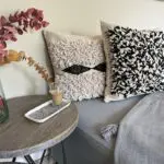 Handwoven cushion covers in beige with wool details sitting on a sofa corner