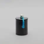 Round stucco jar in black with blue tassel