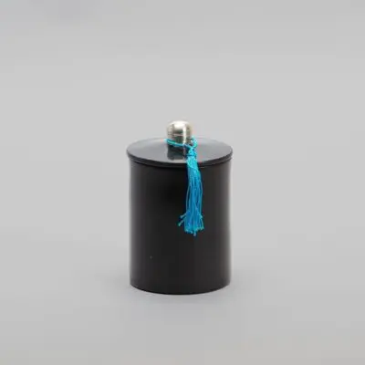 Round stucco jar in black with blue tassel