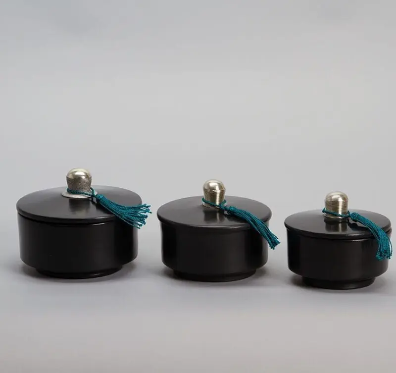 Pots ronds noirs en stuc marocains faits à la main avec pompons bleus