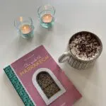 Moroccan handmade cup with in white with black dot pattern next to book and tealight holders