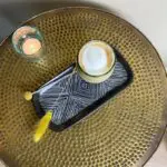 Marokkanisches mundgeblasenes Beldi-Glas mit Kaffee auf dem Tisch mit anderen marokkanischen Dekorationen