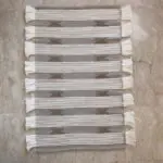 Handwoven cotton rug in beige with Moroccan stripe and dot pattern in shades of brown with white tassels