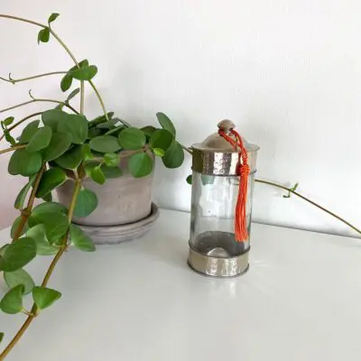 Moroccan handmade glass jar next to a plant