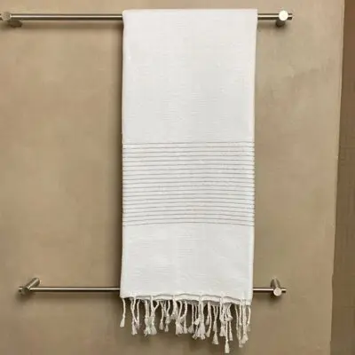 Moroccan handwoven hammam towel with silver stripes hanging out in a bathroom