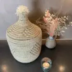 Moroccan handmade basket in white with gold threads next to other decorations