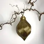 Moroccan handmade twisting drop shaped lamp hanging on a branch