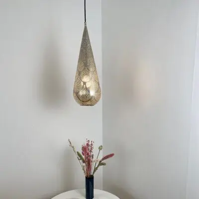 Lampe marocaine artisanale en forme de goutte, suspendue au dessus d'une table décorative