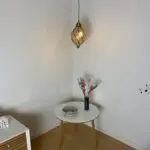 Marockansk handgjord vridande droppformad lampa hängande ovanför ett dekorativt bord