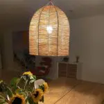 Moroccan handmade raffia lamp in star-shaped wicker, hung above a dining table