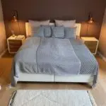 Moroccan handwoven bedspread with gray square pattern on a made bed