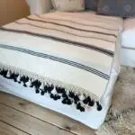 Marockansk handvävd pläd i vitt med svarta ränder, liggande på en soffa