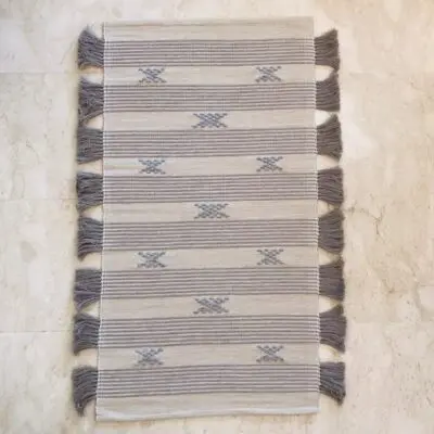 Handgeweven katoenen vloerkleed in wit met Marokkaans streep- en stippenpatroon in lichtblauw met bruine kwastjes