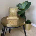 Square Moroccan handmade table lamp with Moroccan pattern on top of patinated brass table