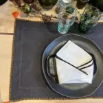 Kolgrå marockanska handbroderade bordstabletter med orange pompoms och bård