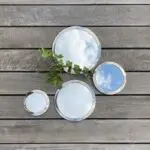 Three round Moroccan handmade mirrors in silver metal in different sizes with decorations around