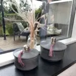 Gray round low Moroccan handmade stucco jars with pink tassels