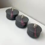 Grå runda låga marockanska handgjorda stuckaturburkar med rosa tofsar